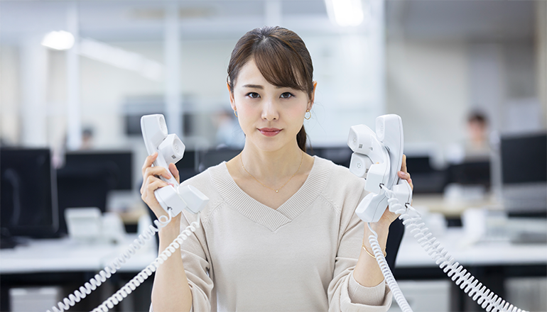 受話器を複数持つ女性